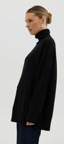 Woman wearing a black turtleneck sweater against a white background