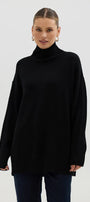 Woman wearing a black turtleneck sweater against a white background