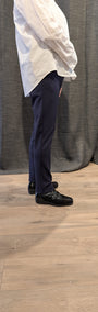 Side view  a white shirt and navy pants.