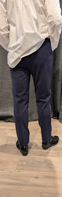Back view white shirt and navy pants.