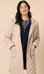 Woman wearing a beige quilted coat against a beige background