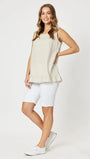 A female model wearing a beige ruffle hem linen tank top with a round neckline, short sleeves, and a midi length.